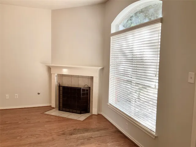 a view of an empty room with a fireplace and a window