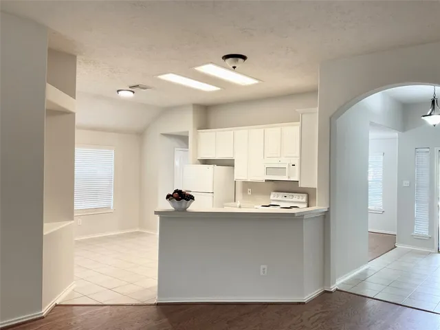 a kitchen with white cabinets appliances and a sink