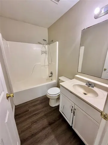 a bathroom with a granite countertop sink toilet a mirror and shower