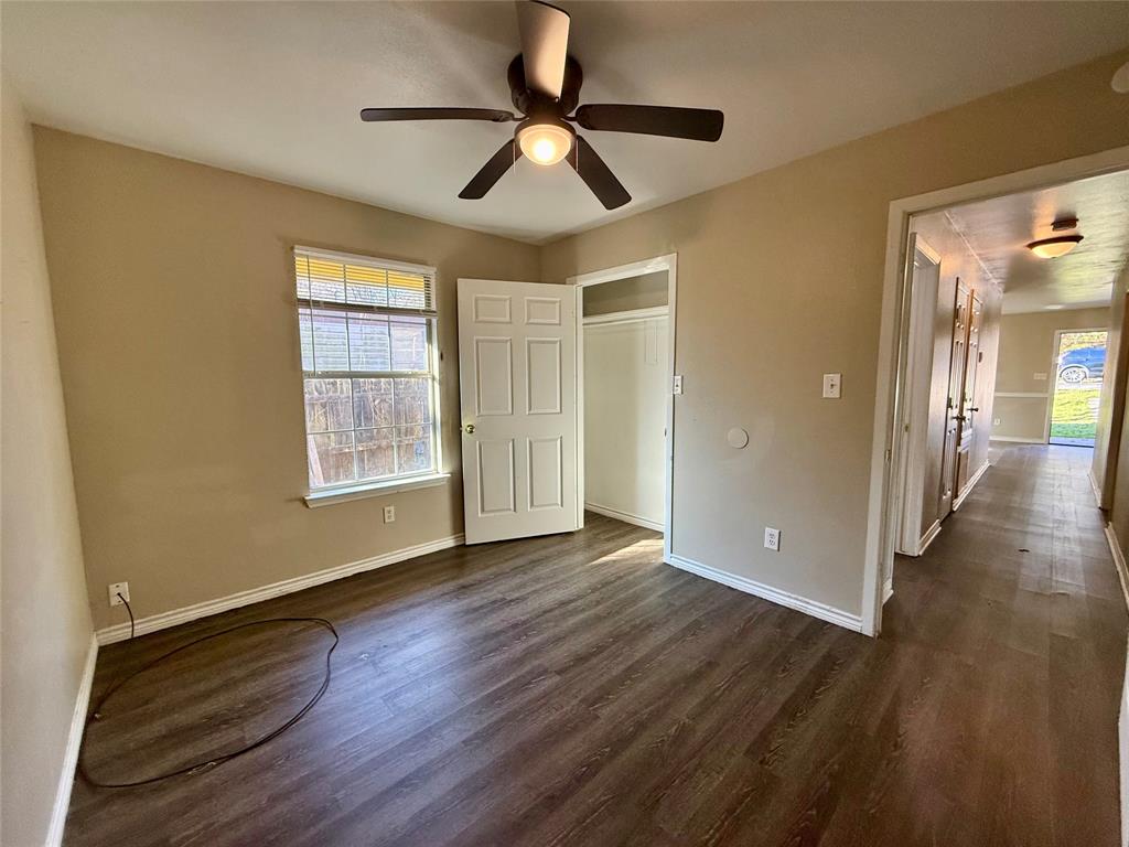 104 East Prospect Street Denison, TX 75021 - Photo 10 of 12 a view of an empty room with wooden floor and a window