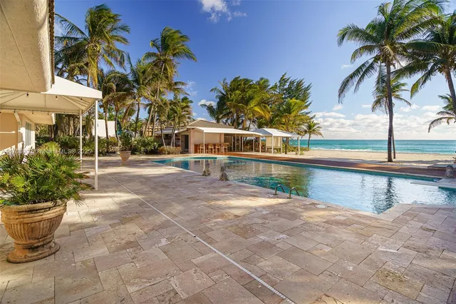 a front view of a house with yard and swimming pool
