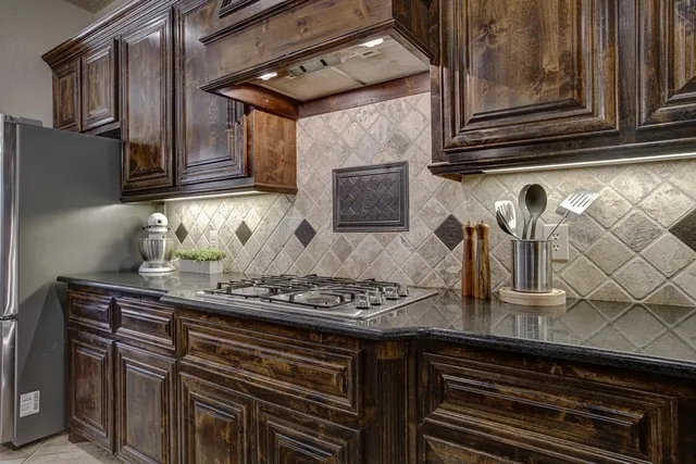 a kitchen with stainless steel appliances granite countertop a sink stove and cabinets