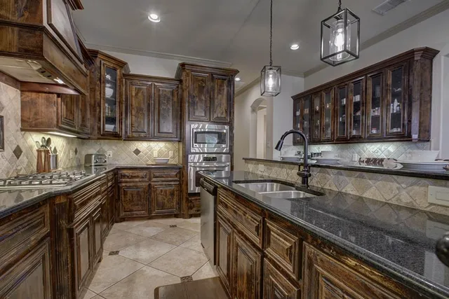 a kitchen with a sink stainless steel appliances cabinets and a counter top space