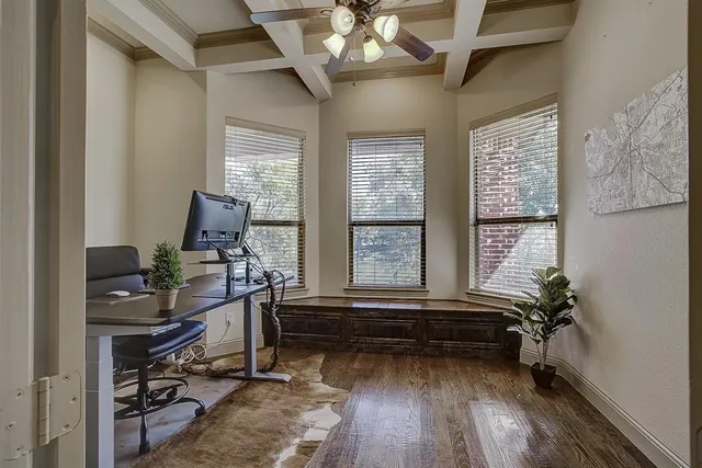 a room with chandelier fan and windows