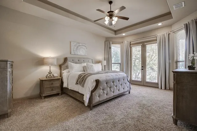 a spacious bedroom with a bed and a chandelier