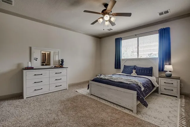 a spacious bedroom with a bed and a dresser