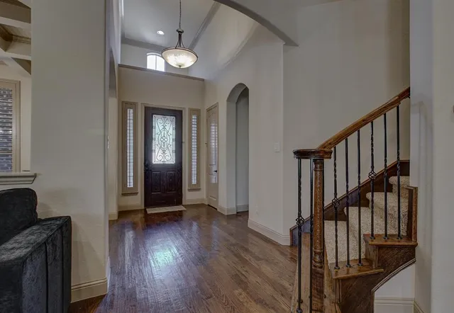 a view of a livingroom with wooden floor and stairs
