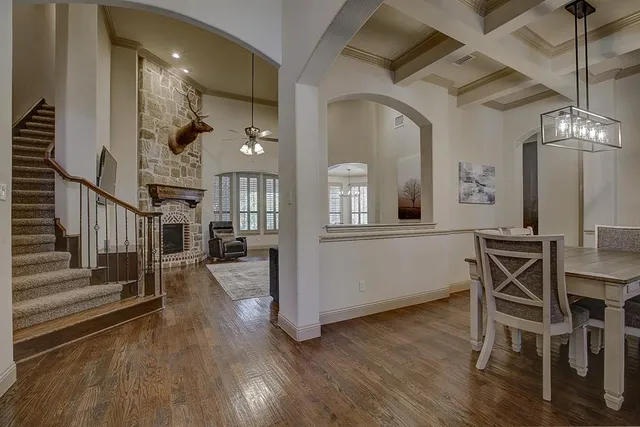 a view of a hallway with wooden floor and dining room
