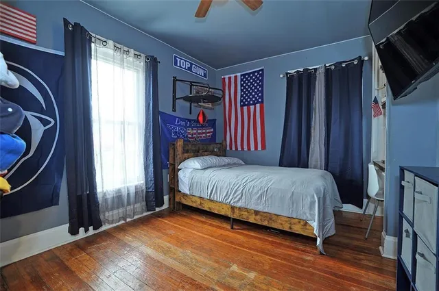 a bedroom with a bed window and a flat screen tv
