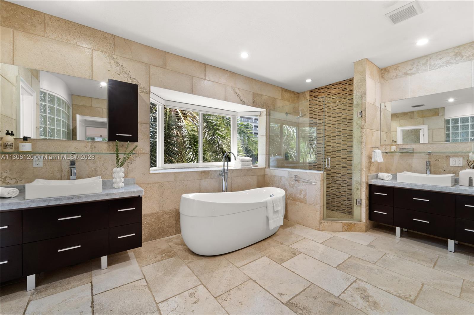 6300 Allison Road Miami Beach, FL 33141 - Photo 11 of 24 a spacious bathroom with a tub sink and mirror