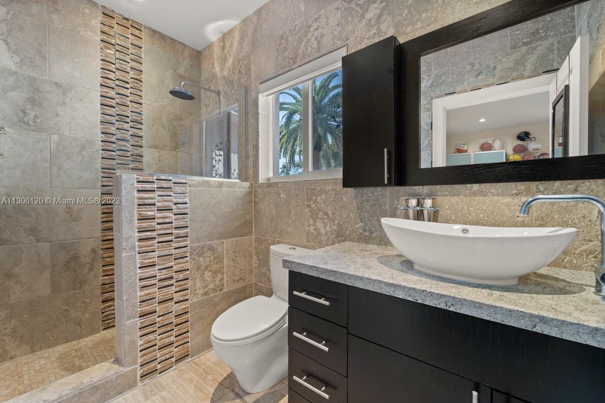 6300 Allison Road Miami Beach, FL 33141 - Photo 17 of 24 a bathroom with a granite countertop toilet sink and mirror