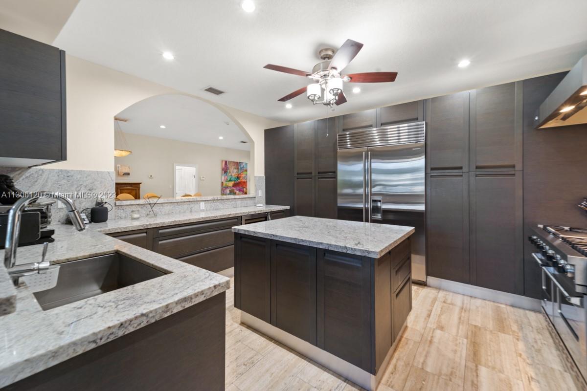 6300 Allison Road Miami Beach, FL 33141 - Photo 9 of 24 a kitchen that has a sink a stove and a table with wooden floor