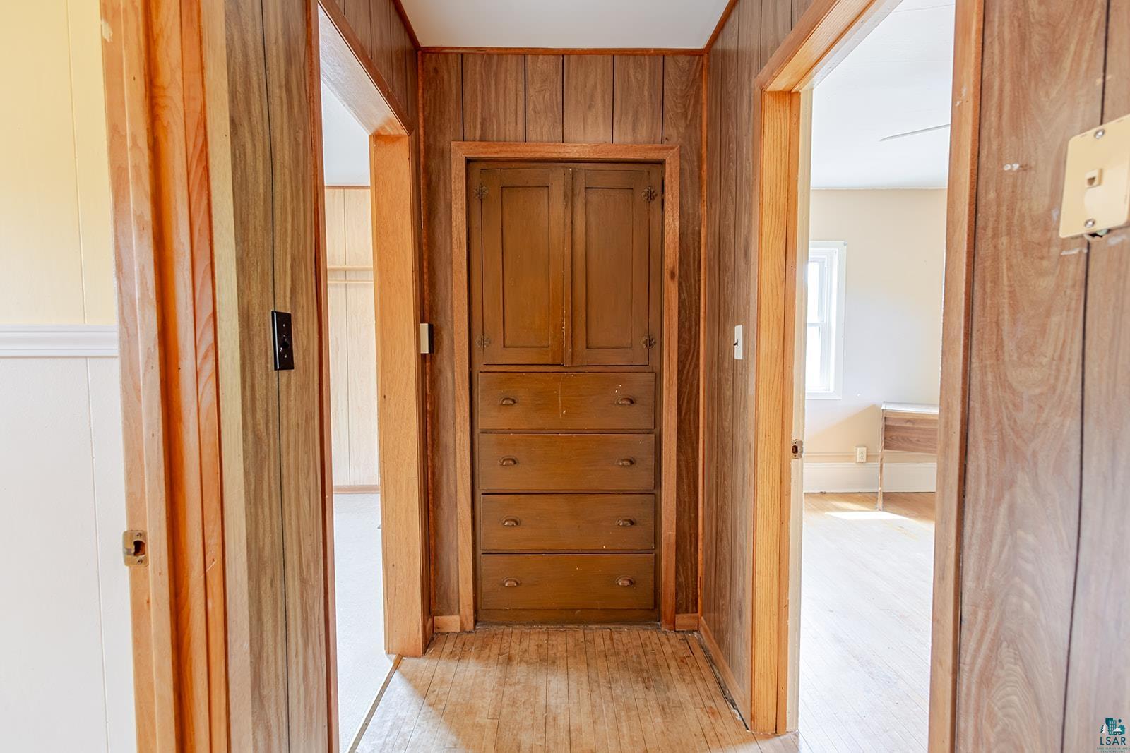 438 9th Street Cloquet, MN 55720 - Photo 21 of 27 Hallway featuring wood-panel walls and built-in wood cabinetry with four drawers