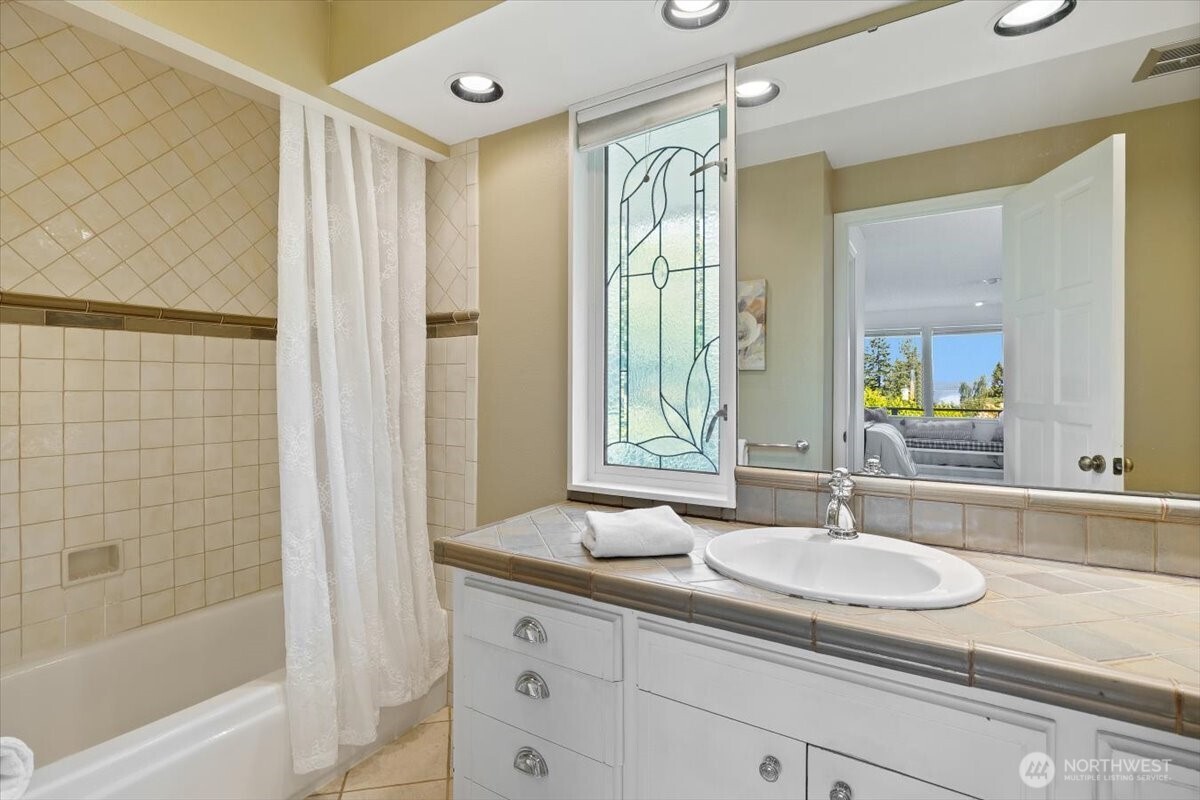 2606 49th Place Southwest Everett, WA 98203 - Photo 16 of 37 a bathroom with a granite countertop sink a mirror and a bathtub