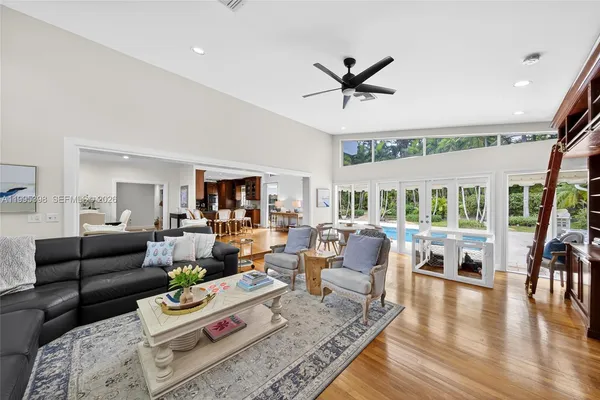 a living room with furniture floor to ceiling window and wooden floor