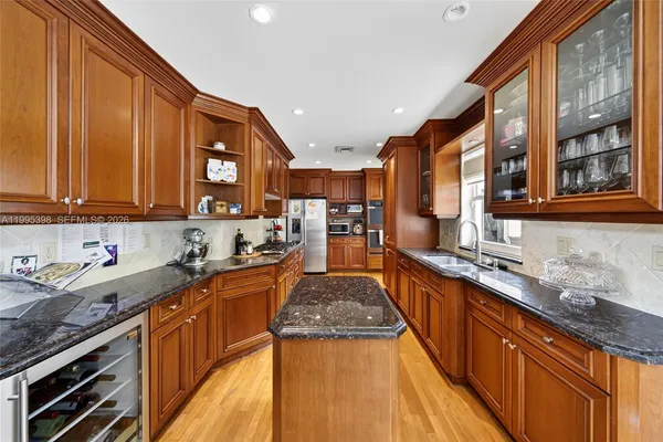 a kitchen with stainless steel appliances granite countertop wooden cabinets a sink dishwasher a stove and a refrigerator