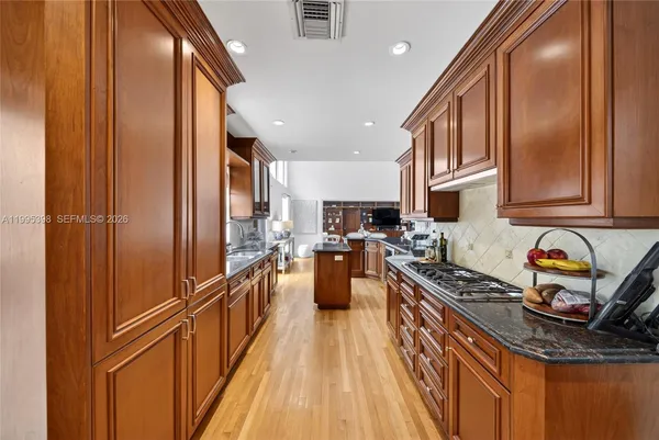 a kitchen with stainless steel appliances granite countertop a refrigerator a stove top oven a sink and dishwasher