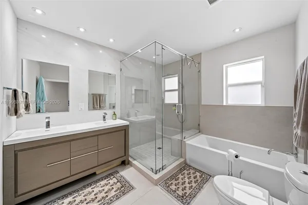 a spacious bathroom with a double vanity sink mirror and toilet