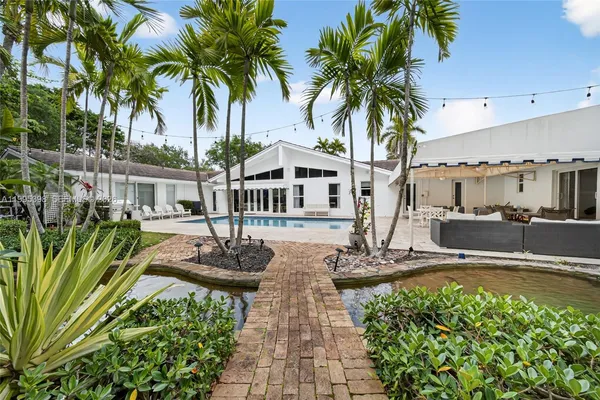 a view of a house with swimming pool and sitting area