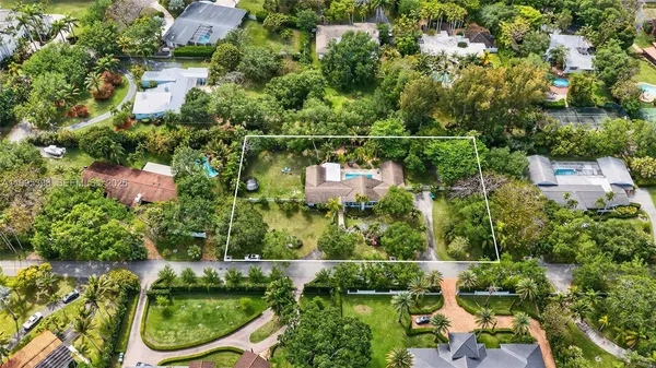 an aerial view of residential house with yard and swimming pool
