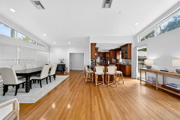 a dining room with lots of wooden furniture and stainless steel appliances