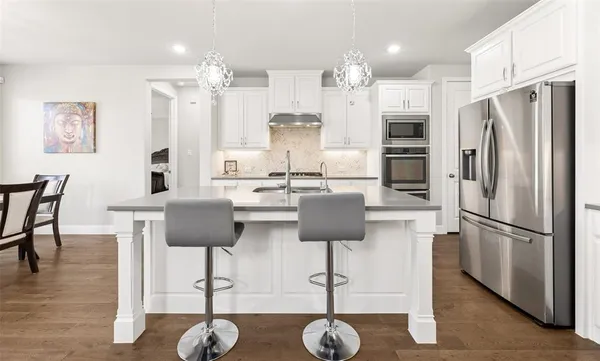 a kitchen with white cabinets and appliances