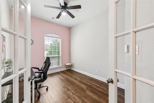 a view of staircase with lots of frames on wall and wooden floor