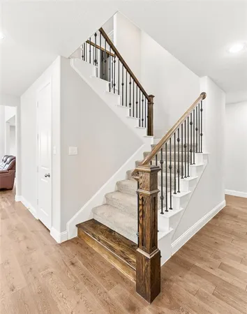 a hallway with wooden floor and staircase