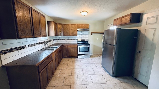 305 East Milam Street Pettus, TX 78416 - Photo 11 of 21 a kitchen with stainless steel appliances granite countertop a refrigerator a stove and a sink
