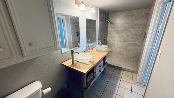 a bathroom with a granite countertop toilet sink and mirror