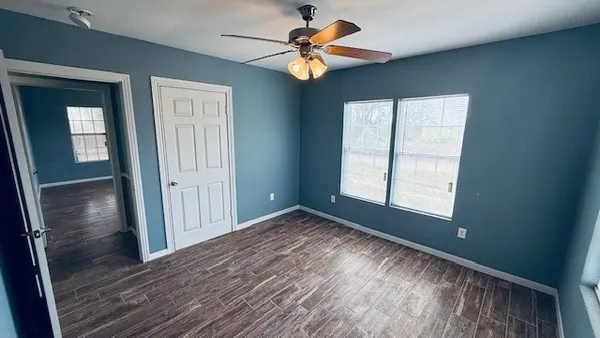 a view of room with window ceiling fan and hardwood floor