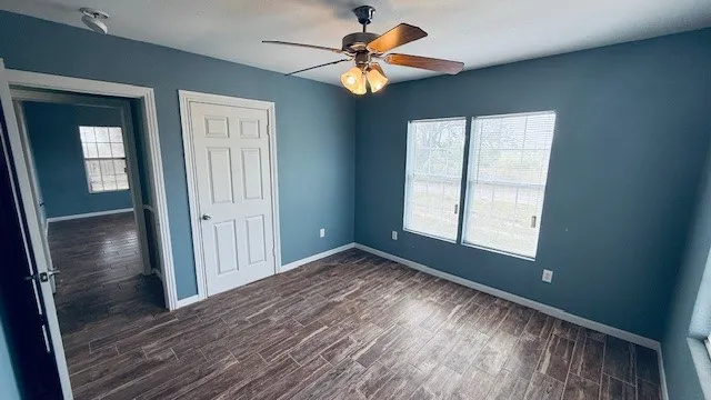 a view of room with window ceiling fan and hardwood floor