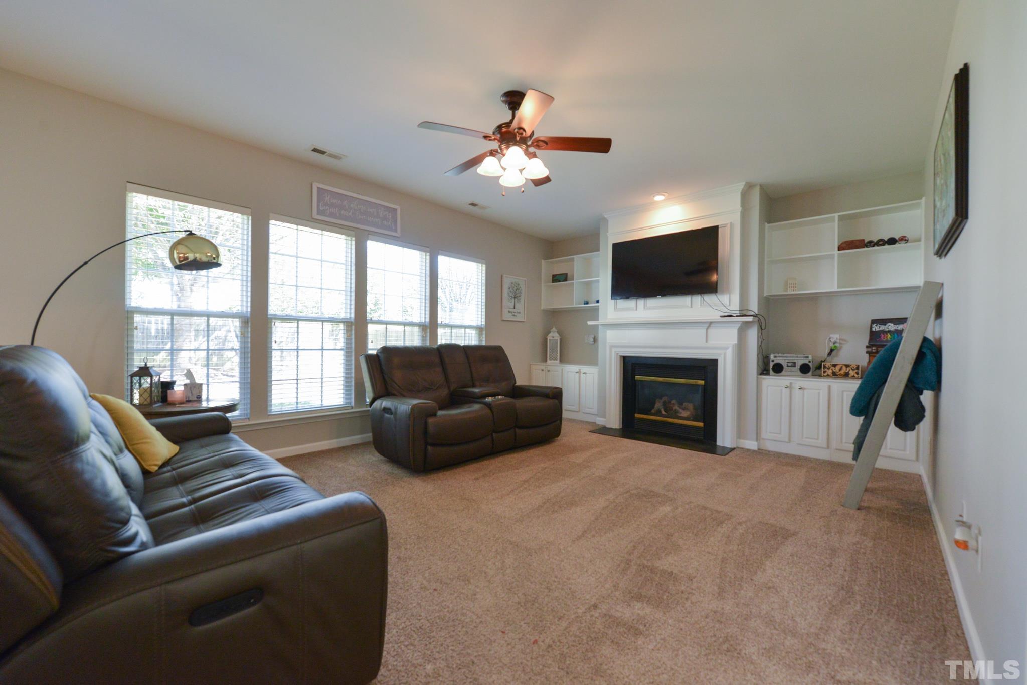 1513 Nealstone Way Raleigh, NC 27614 - Photo 14 of 30 a living room with furniture a fireplace and a flat screen tv