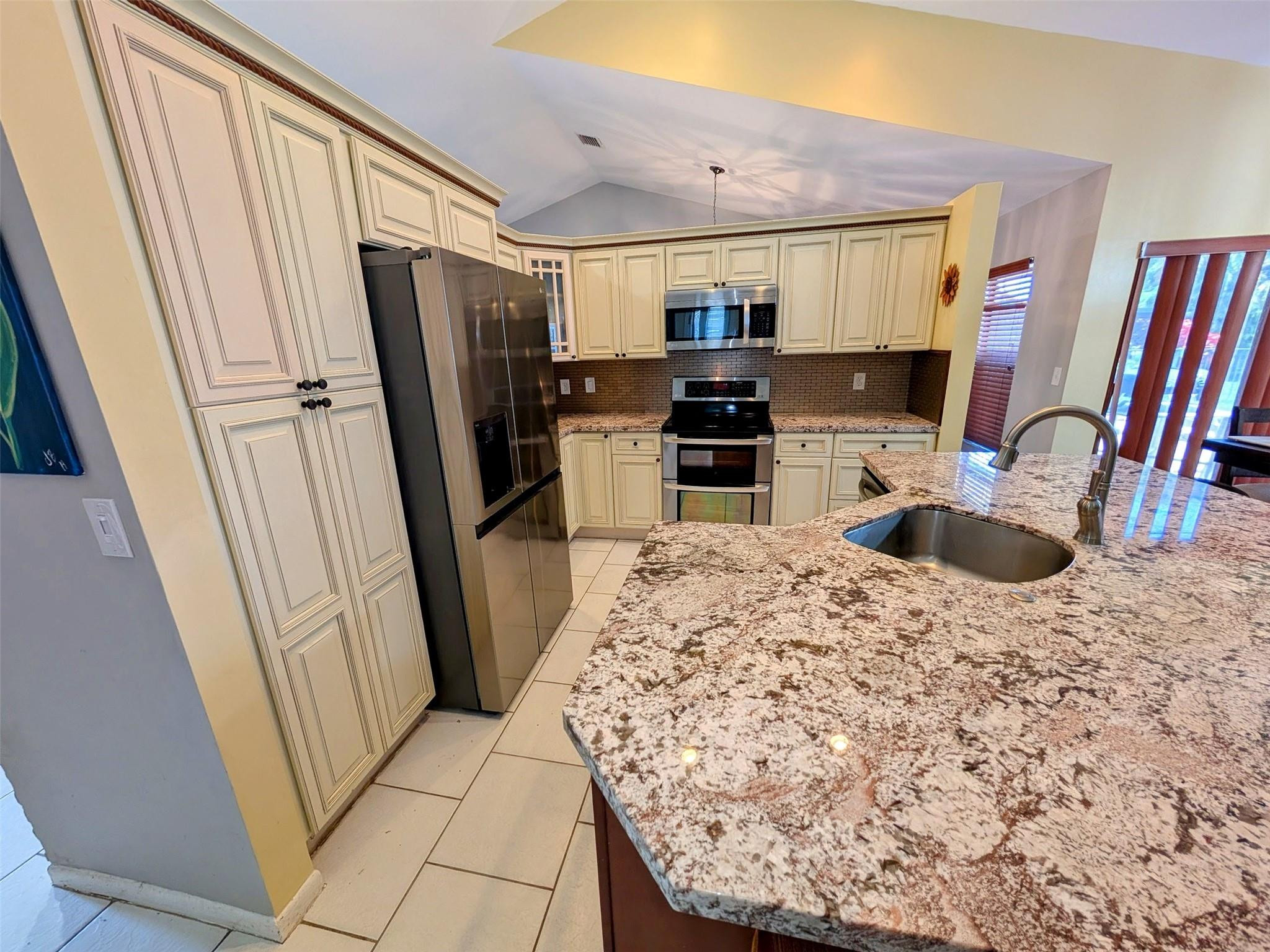 9460 El Clair Ranch Road Boynton Beach, FL 33437 - Photo 7 of 30 a kitchen with stainless steel appliances a refrigerator a sink a stove a microwave a refrigerator and cabinets