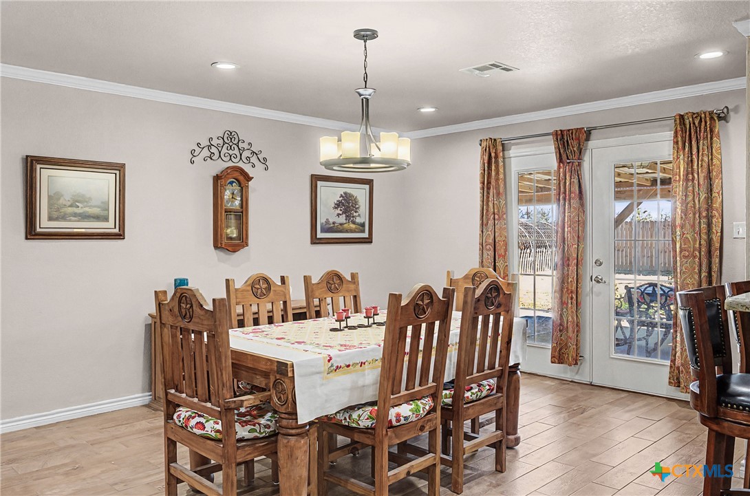 1601 Sunset Circle Cameron, TX 76520 - Photo 12 of 40 a dining room with furniture wooden floor and a chandelier