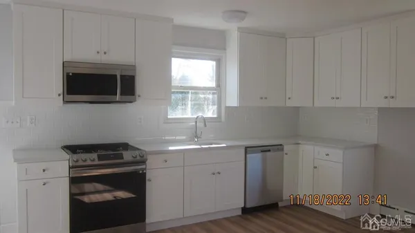 a kitchen with cabinets appliances and a window