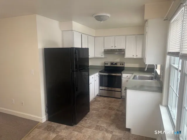 a kitchen with stainless steel appliances granite countertop a refrigerator and a stove