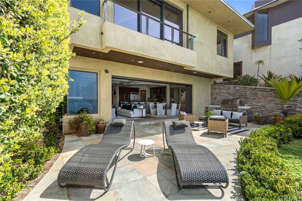 11 Camel Point Drive Laguna Beach, CA 92651 - Photo 38 of 67 a view of a patio with couches table and chairs potted plants and a palm tree