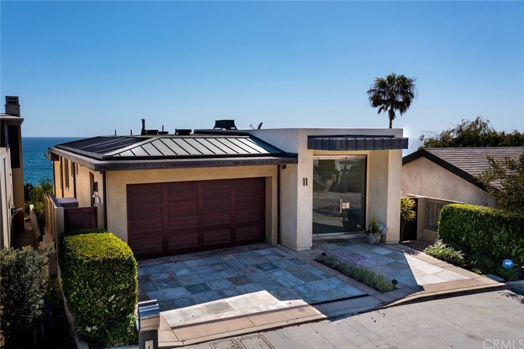 11 Camel Point Drive Laguna Beach, CA 92651 - Photo 62 of 67 a front view of a house with a yard and garage