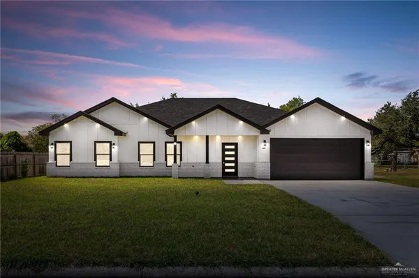 a front door view of a house with a yard and garage