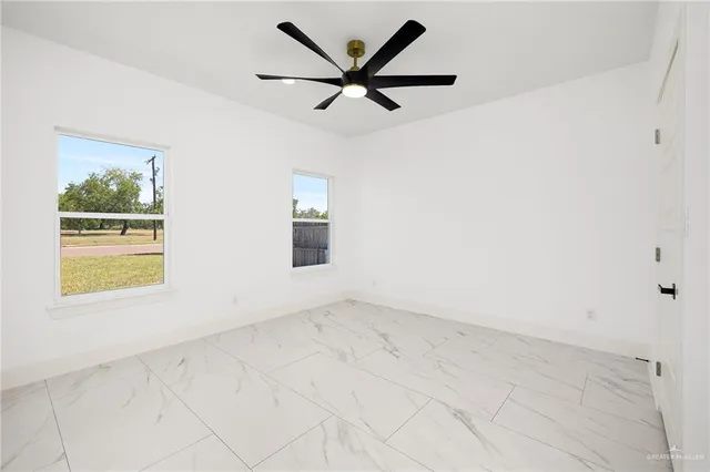 an empty room with a window and a ceiling fan