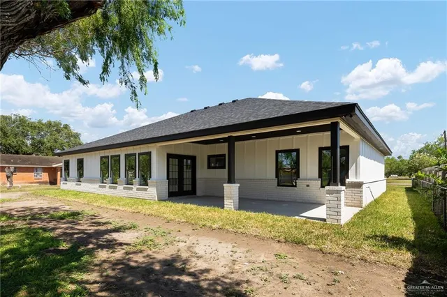 a front view of a house with a yard and potted plants
