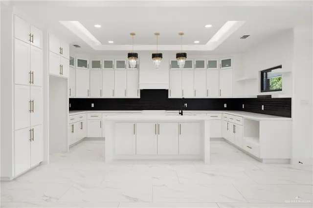 a kitchen with white cabinets and sink