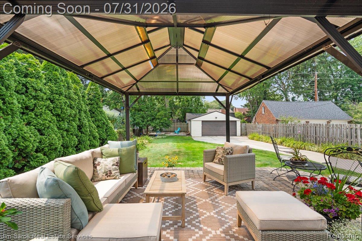 Expansive paver patio featuring a covered pergola structure