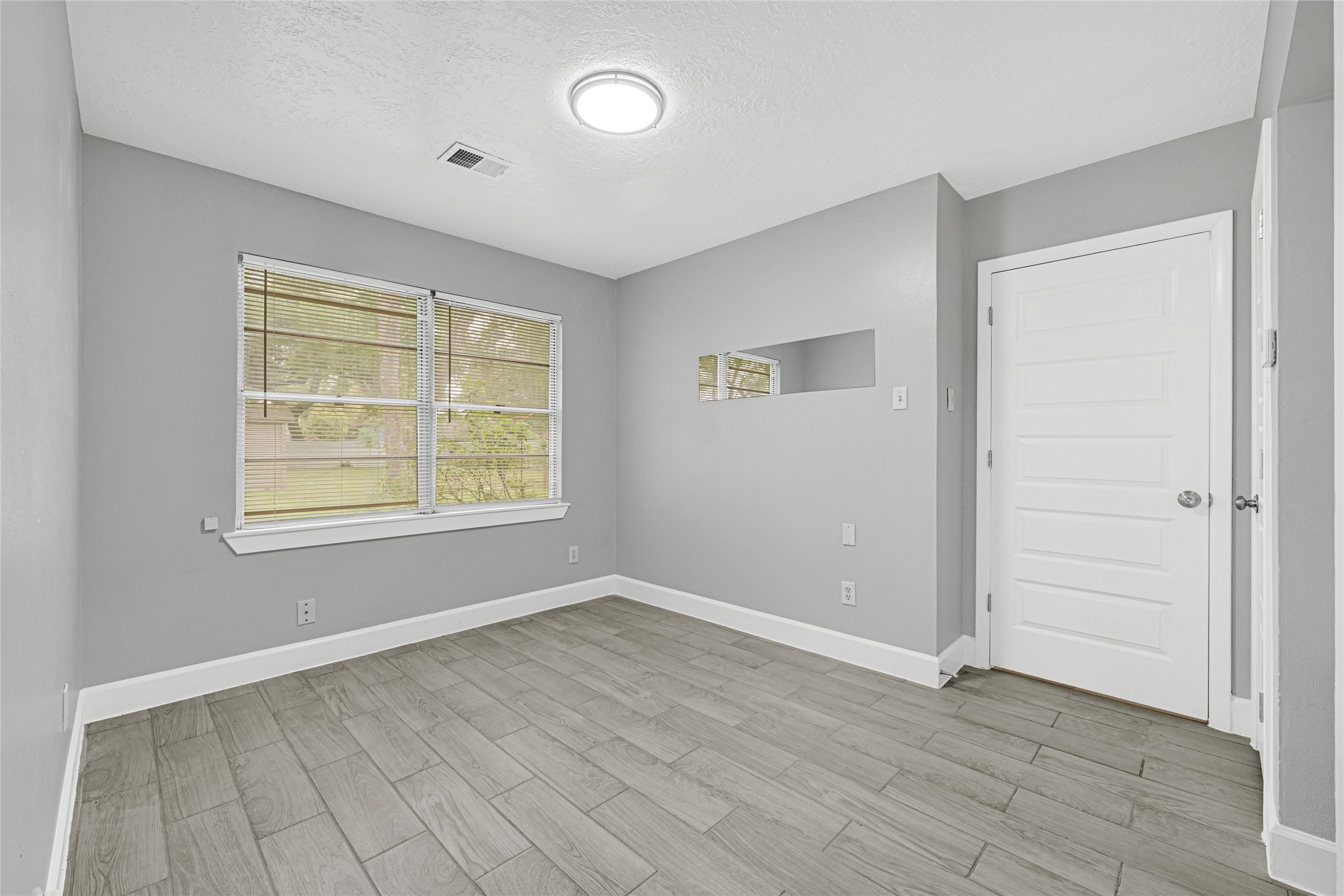 205 Grammar Road Houston, TX 77047 - Photo 13 of 26 an empty room with wooden floor and windows