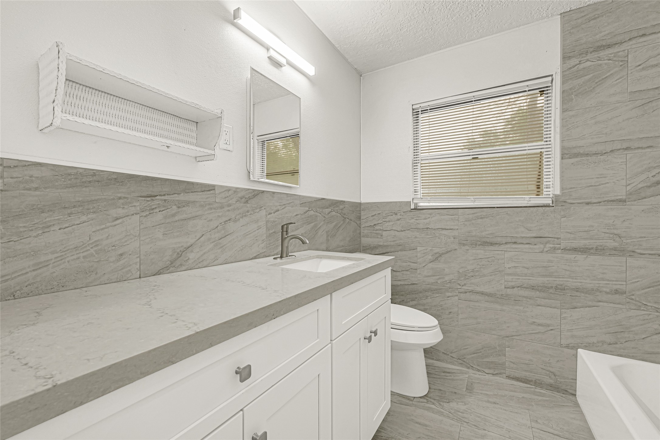 205 Grammar Road Houston, TX 77047 - Photo 18 of 26 a bathroom with a granite countertop sink a toilet and a mirror