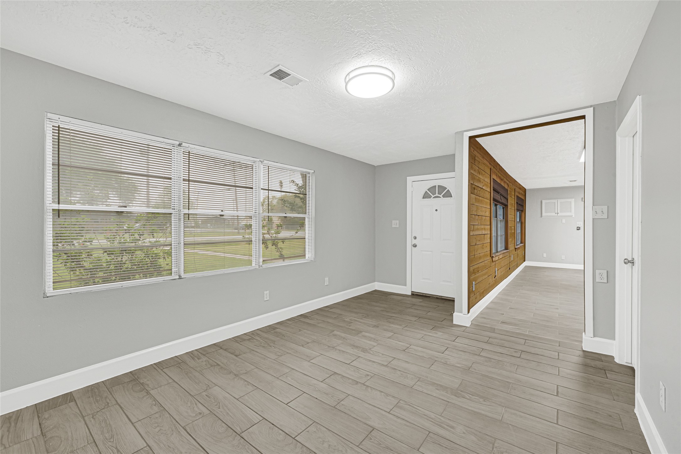 205 Grammar Road Houston, TX 77047 - Photo 4 of 26 an empty room with wooden floor and windows