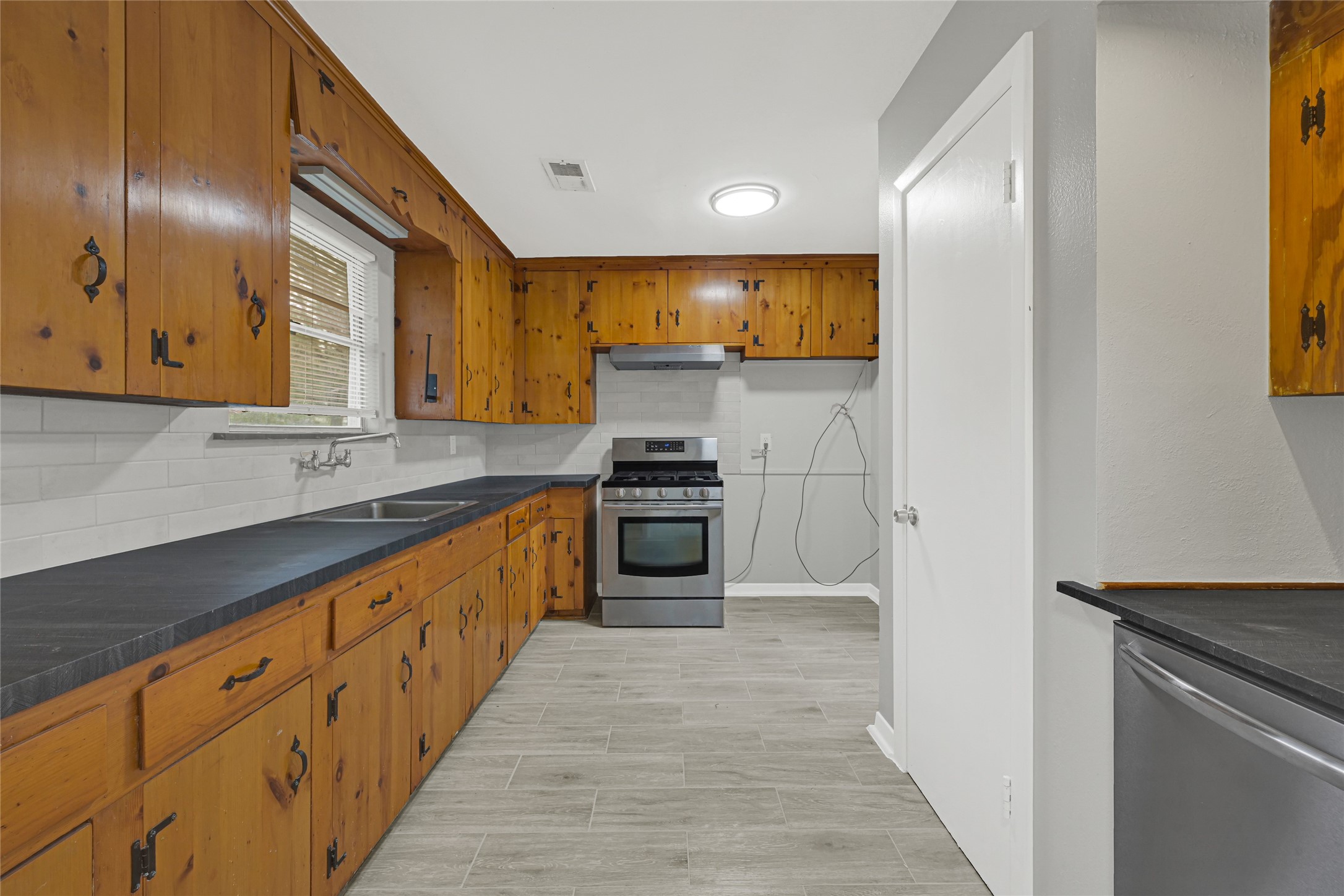 205 Grammar Road Houston, TX 77047 - Photo 9 of 26 a large kitchen with granite countertop a stove and a sink