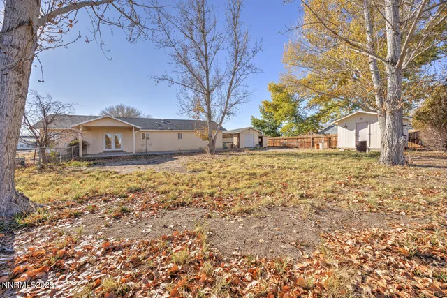 a view of a yard with wooden fence