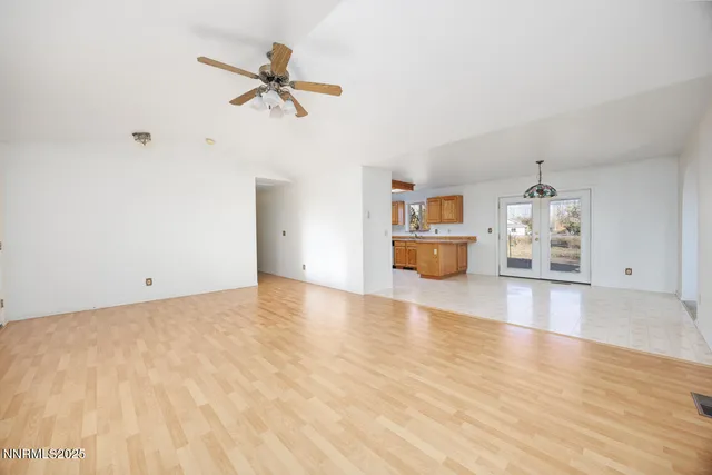 a view of empty room with wooden floor and ceiling fan
